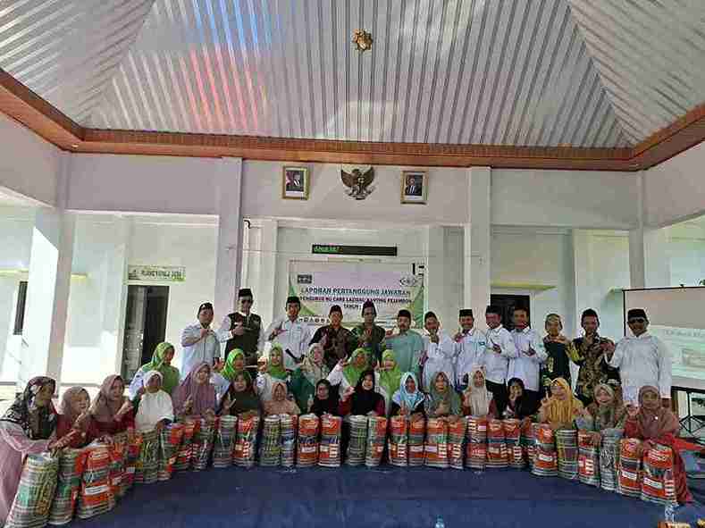 Pengurus LAZISNU Ranting Pajembon bersama warga Nahdliyin saat penyaluran karpet dan laporan pertanggungjawaban di Aula Desa Pajembon, Bojonegoro