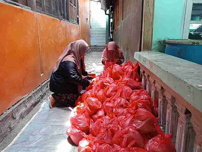 Relawan Mata Basah mengemas paket nasi takjil Ramadhan dalam kantong merah untuk dibagikan kepada santri dan dhuafa di Bojonegoro.
