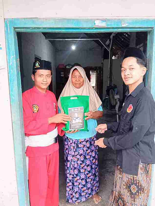 Anggota Pagar Nusa Kenep Balen menyerahkan bantuan zakat kepada warga dhuafa di Desa Kenep Bojonegoro saat Ramadan 1447 H