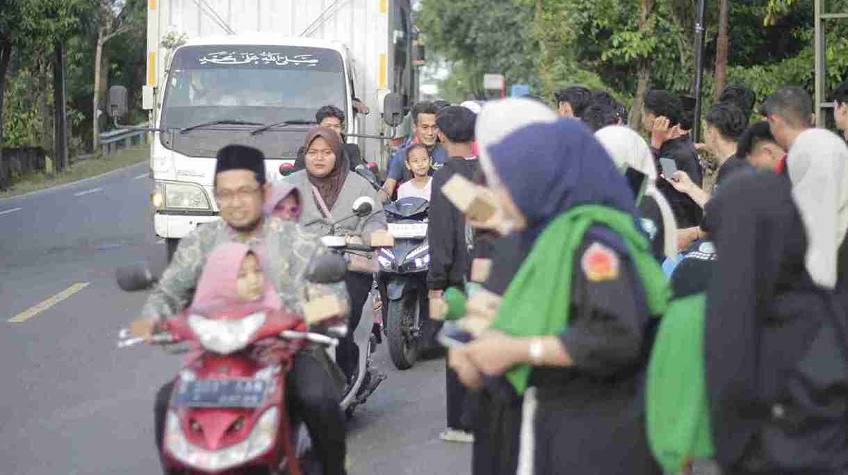 Anggota Pagar Nusa Ranting Kabunan Balen Bojonegoro membagikan takjil kepada pengguna jalan pada Ramadhan 1447 H