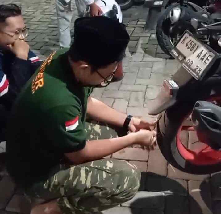 Banser Baureno dan Balen memperbaiki motor pemudik di posko mudik dini hari