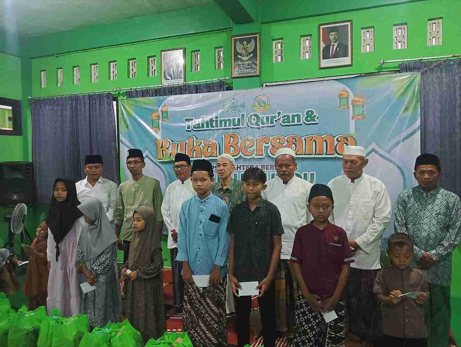 Penyerahan santunan kepada anak-anak dalam acara Takhtimul Qur’an dan buka bersama BMTNU Kalitidu