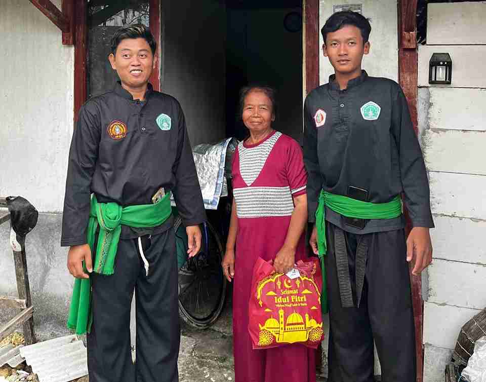 Anggota Pagar Nusa Bayemgede menyerahkan paket sembako kepada warga dalam kegiatan bakti sosial Ramadan di Kepohbaru Bojonegoro