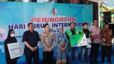 Penyerahan manfaat BPJS Ketenagakerjaan kepada ojol saat May Day Bojonegoro 2026