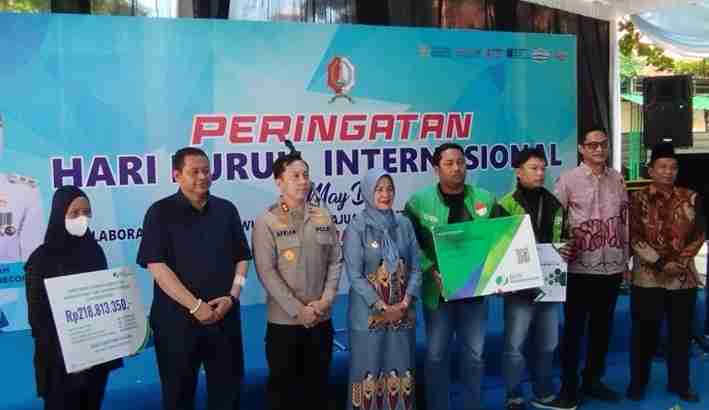Penyerahan manfaat BPJS Ketenagakerjaan kepada ojol saat May Day Bojonegoro 2026
