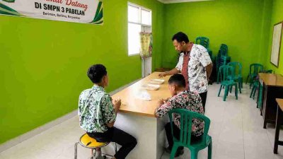 Dua siswa SMPN 1 Purwosari Bojonegoro saat melakukan penelitian pemanfaatan bonggol pisang menjadi bahan kesehatan alternatif di laboratorium sekolah.