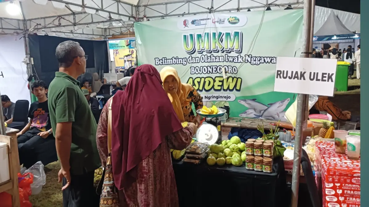 Pengunjung membeli rujak buah dan aneka camilan di stand UMKM milik Abdul Jalal pada Bojonegoro Wastra Batik Festival 2026 di Alun-Alun Bojonegoro.