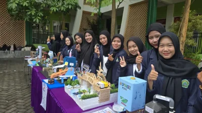 Sejumlah mahasiswi berdiri di samping meja pameran yang menampilkan berbagai miniatur dan karya inovatif dalam kegiatan gelar karya mahasiswa.