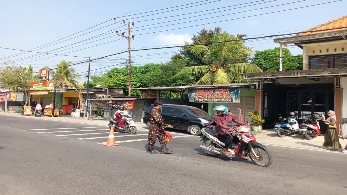 Anggota Banser Dander mengatur lalu lintas saat penerimaan rapor MTs Abu Darrin.
