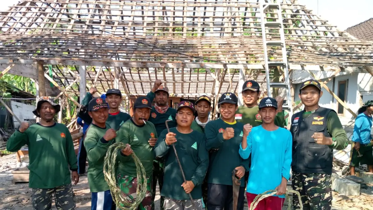 Anggota Banser Satkoryon Kalitidu bergotong royong membantu pembongkaran rumah anggota di Dusun Gangsalan, Desa Kalitidu, Bojonegoro.