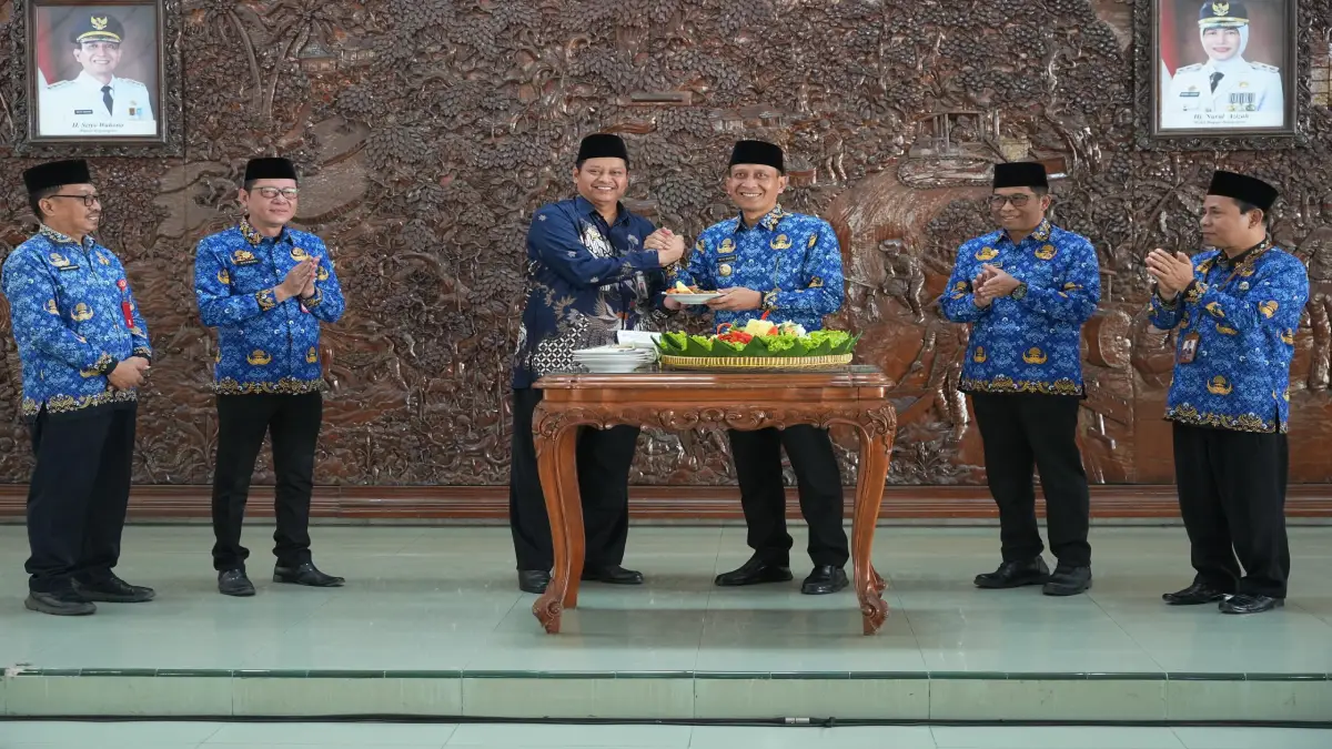 Bupati Bojonegoro menyerahkan potongan tumpeng dalam peringatan Hari Koperasi Nasional, Hari Keluarga Nasional, dan Hari Anak Nasional Tahun 2026 di Gedung Putih Pemkab Bojonegoro.