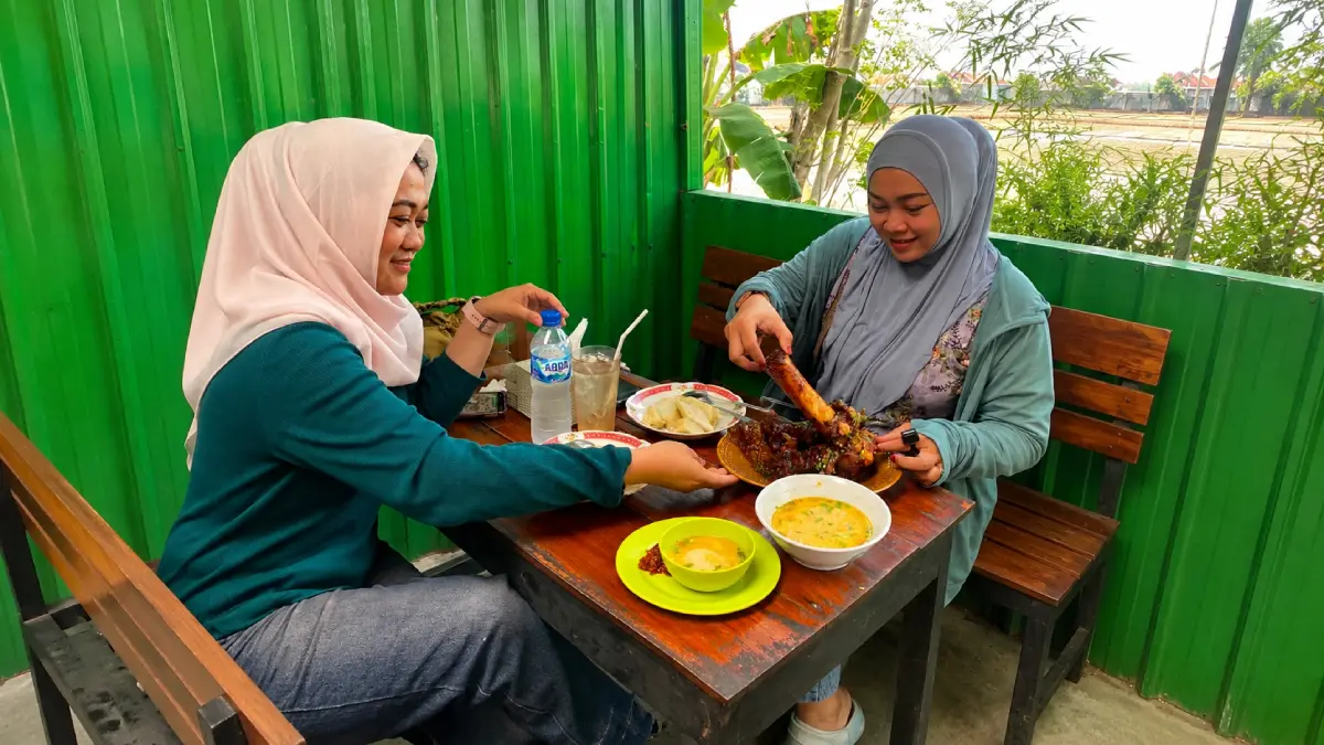 Pengunjung menikmati hidangan Kikil Bakar Jumbo di Warung Kikil Bakar Arjuno, Jalan Lisman No. 9A, Bojonegoro.