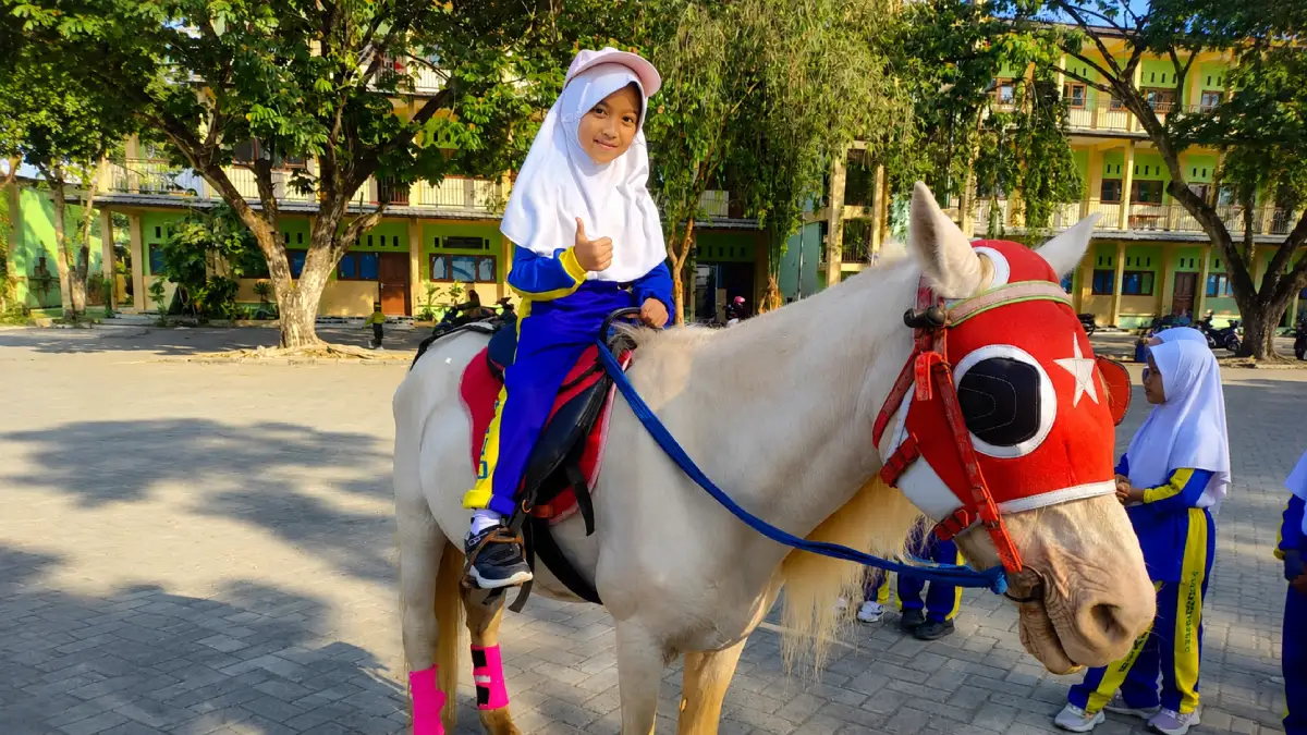 Siswa MI Al-Rosyid Bojonegoro mengikuti olahraga berkuda untuk melatih motorik, keberanian, dan kemandirian.