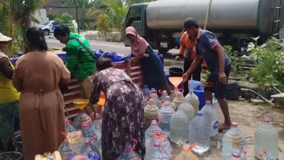 Polisi dan ojol membantu warga mendapatkan air bersih di Bojonegoro