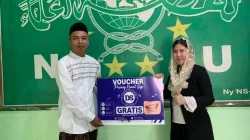drg. Melly Utarini menyerahkan voucher pasang kawat gigi gratis untuk Jalan Sehat PCNU Bojonegoro.